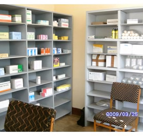 les locaux du dépôt Cameg (rayonnages de médicaments/cartons et deux fauteuils), datée 2009/03/25